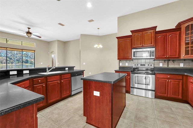 kitchen with a kitchen island, decorative backsplash, sink, stainless steel appliances, and light tile patterned floors