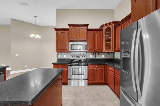 kitchen with a notable chandelier, decorative backsplash, light tile patterned flooring, hanging light fixtures, and stainless steel appliances