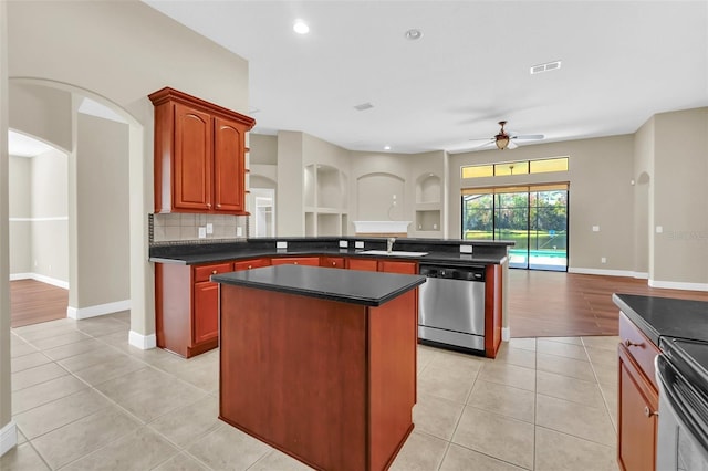 kitchen with ceiling fan, light tile patterned floors, stainless steel appliances, and a kitchen island