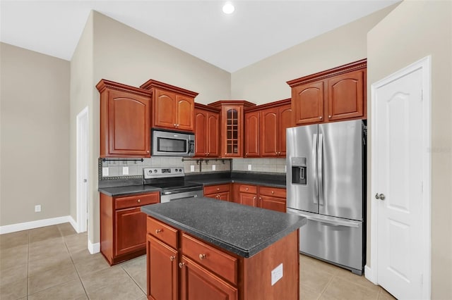 kitchen with light tile patterned floors, stainless steel appliances, backsplash, and a center island