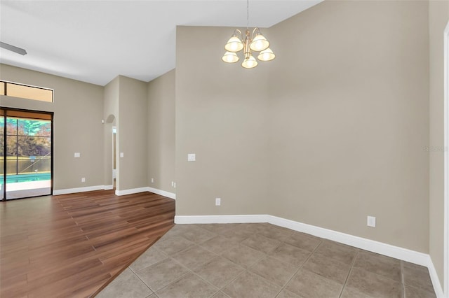 spare room featuring light wood-type flooring and an inviting chandelier