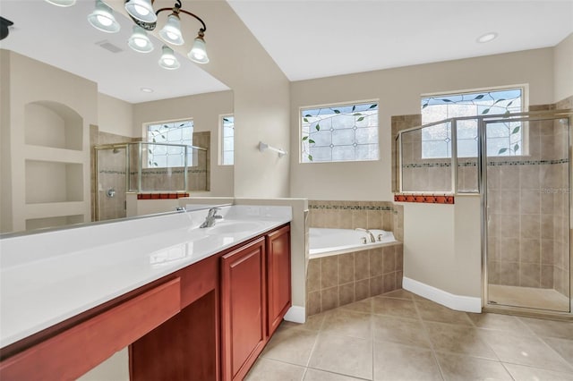 bathroom featuring plus walk in shower, a wealth of natural light, tile patterned floors, and vanity