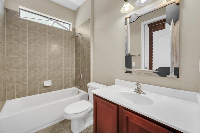 full bathroom featuring toilet, vanity, tiled shower / bath, and tile patterned flooring