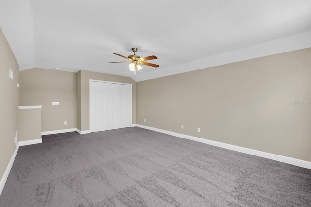 interior space with ceiling fan, a closet, lofted ceiling, and carpet flooring