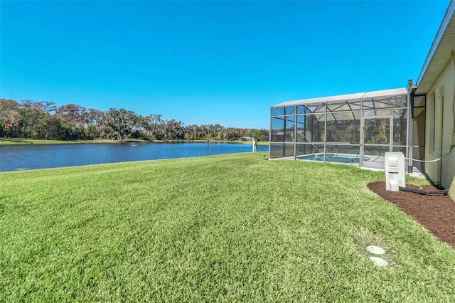 view of yard featuring glass enclosure and a water view