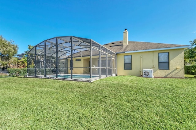 rear view of house featuring a lawn and ac unit