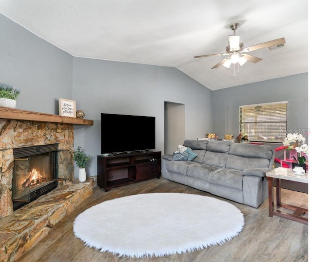 living room featuring vaulted ceiling, ceiling fan, a fireplace, and wood-type flooring