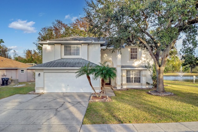 view of front of house featuring a garage, a front lawn, and a water view