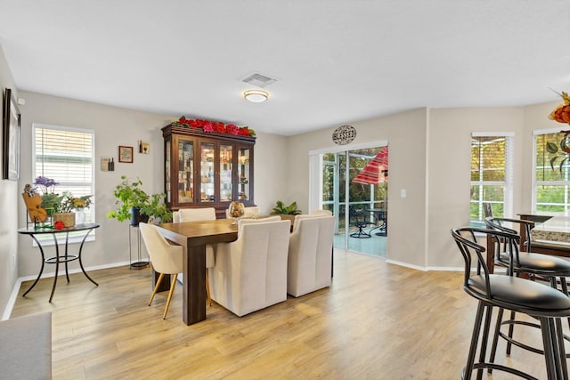 dining space with a wealth of natural light and light hardwood / wood-style flooring