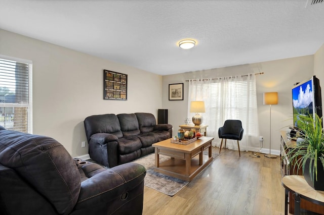 living room featuring a textured ceiling and light hardwood / wood-style flooring