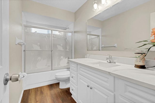 full bathroom featuring toilet, vanity, shower / bath combination with glass door, and hardwood / wood-style flooring