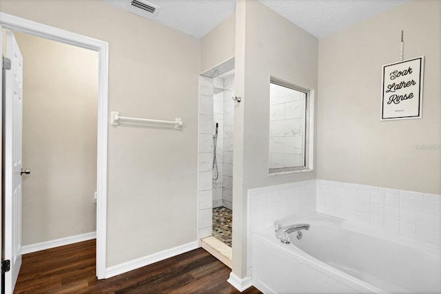 bathroom featuring wood-type flooring and shower with separate bathtub