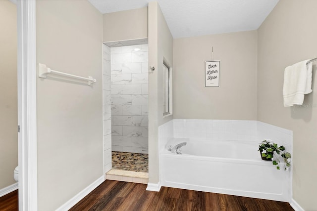 bathroom with toilet, shower with separate bathtub, a textured ceiling, and hardwood / wood-style floors