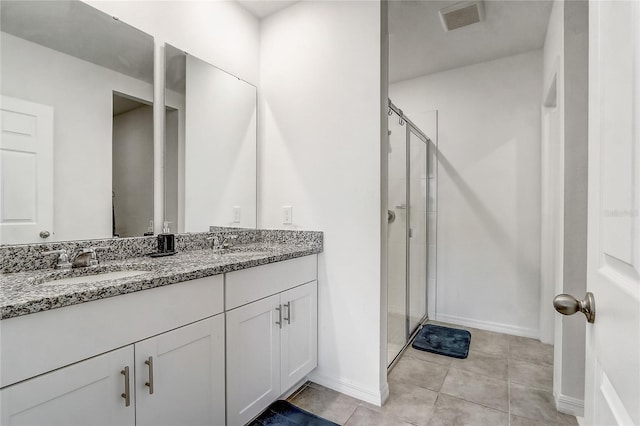 bathroom featuring vanity, tile patterned floors, and a shower with door