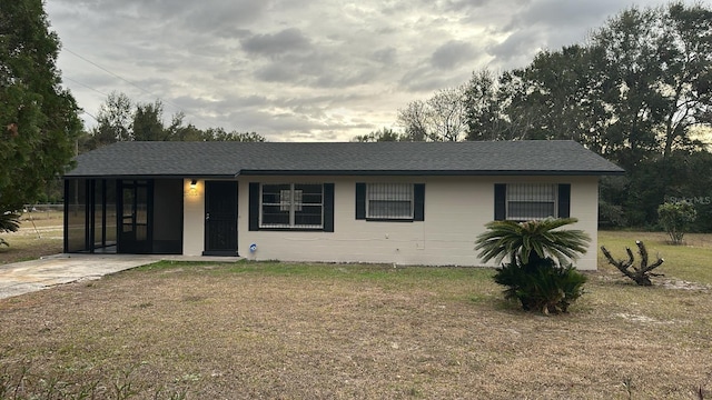 single story home featuring a front lawn and a carport