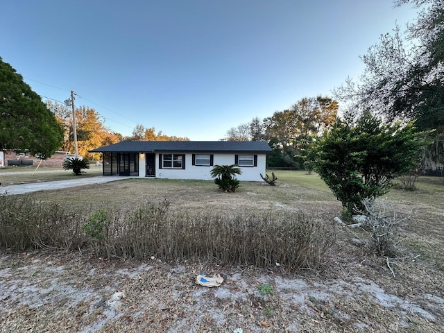 ranch-style home featuring a front lawn and a carport