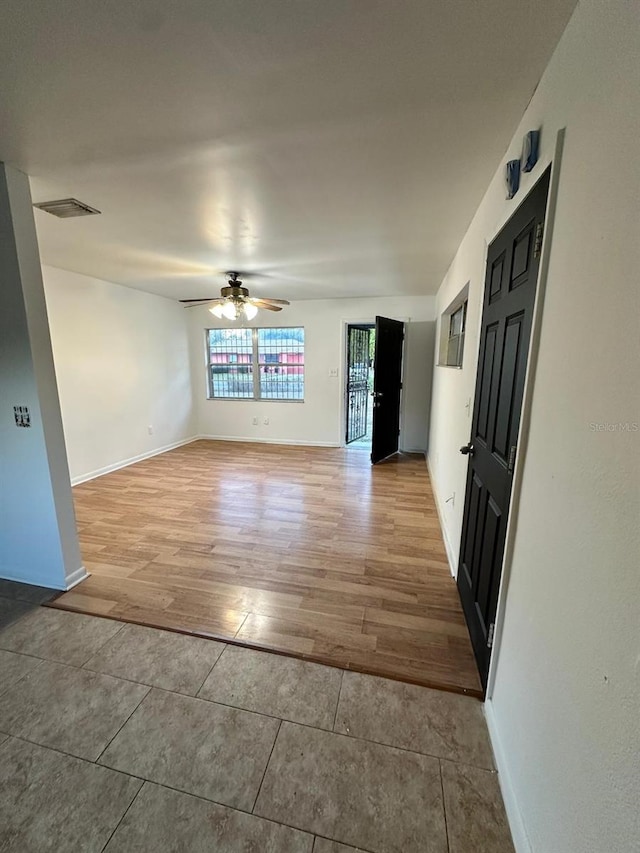 empty room with light wood-type flooring and ceiling fan