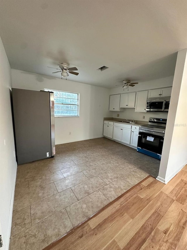 kitchen with sink, ceiling fan, white cabinetry, and appliances with stainless steel finishes