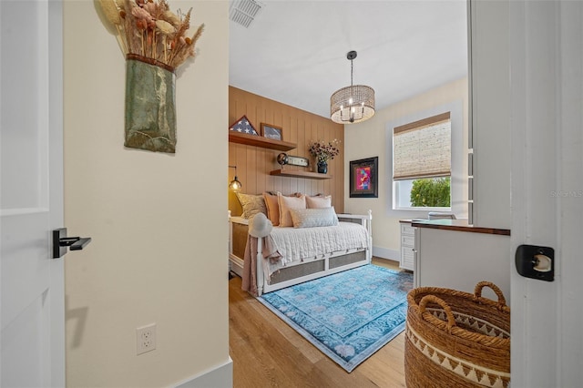 bedroom with a chandelier and light hardwood / wood-style floors