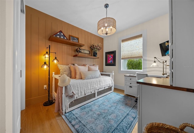 bedroom with a notable chandelier and light hardwood / wood-style floors