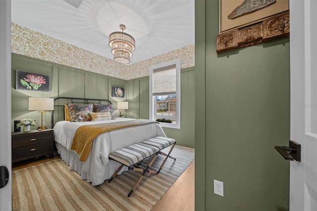 bedroom featuring an inviting chandelier and light wood-type flooring