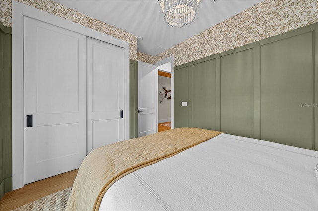 bedroom featuring an inviting chandelier and light hardwood / wood-style floors