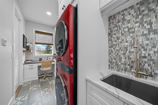 washroom featuring stacked washer and dryer and sink