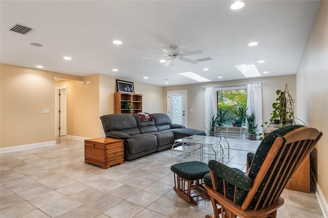 living room with light tile patterned flooring, ceiling fan, and a skylight