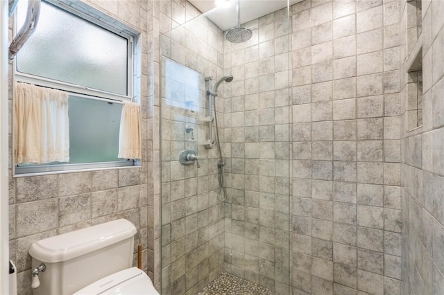 bathroom featuring toilet and tiled shower