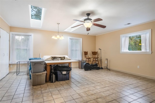 dining room with ceiling fan with notable chandelier, crown molding, a skylight, and light tile patterned flooring