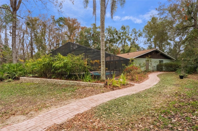 view of side of property with glass enclosure and a yard