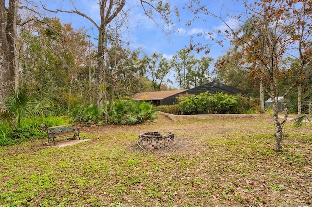 view of yard featuring a lanai and a fire pit