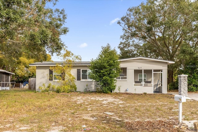 view of front of house with a sunroom and a front yard