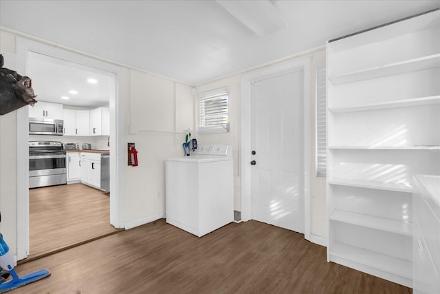 kitchen featuring stainless steel appliances, white cabinetry, washer / dryer, and dark hardwood / wood-style flooring