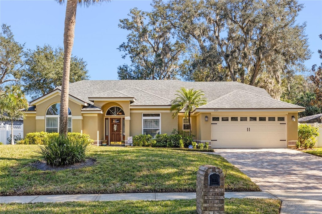 single story home featuring a garage and a front yard