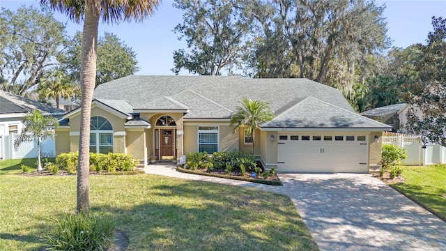 ranch-style home featuring a garage and a front lawn