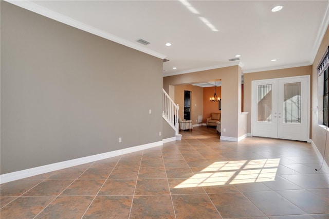 foyer entrance with an inviting chandelier, crown molding, and french doors