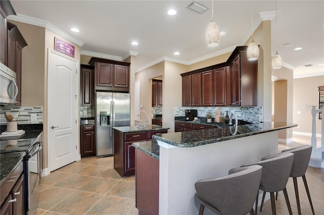 kitchen featuring backsplash, stainless steel appliances, a center island, decorative light fixtures, and dark stone counters