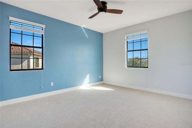 carpeted spare room featuring ceiling fan