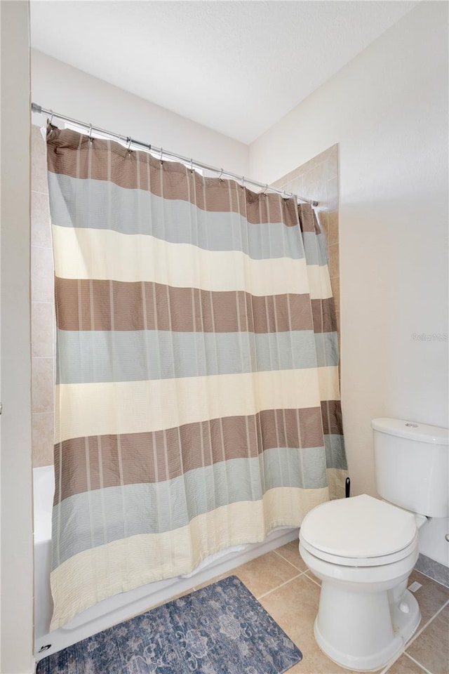 bathroom with tile patterned flooring, shower / bath combo, and toilet