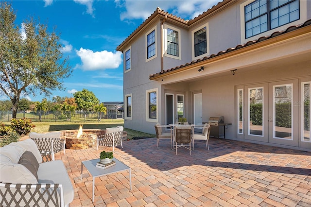 view of patio / terrace featuring french doors, area for grilling, and an outdoor fire pit