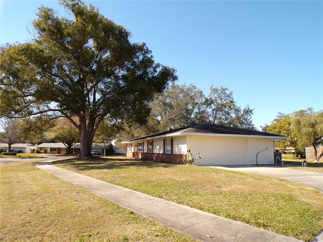 view of side of property with a garage, a yard, concrete driveway, and stucco siding