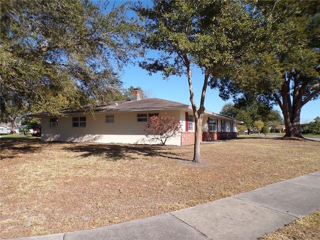 view of home's exterior featuring a yard and a chimney