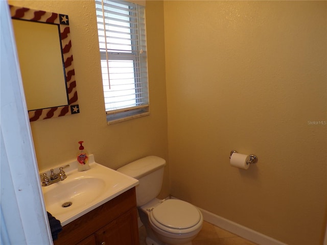 bathroom featuring baseboards, vanity, and toilet