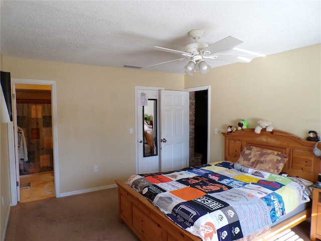 bedroom with a textured ceiling, ceiling fan, light colored carpet, visible vents, and baseboards