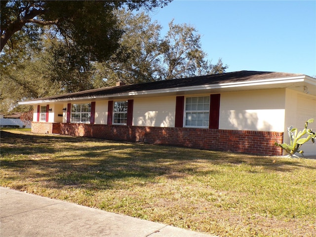 ranch-style house featuring a front lawn and brick siding