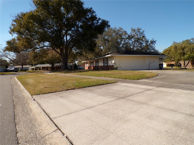 view of property exterior featuring a garage, a yard, and driveway