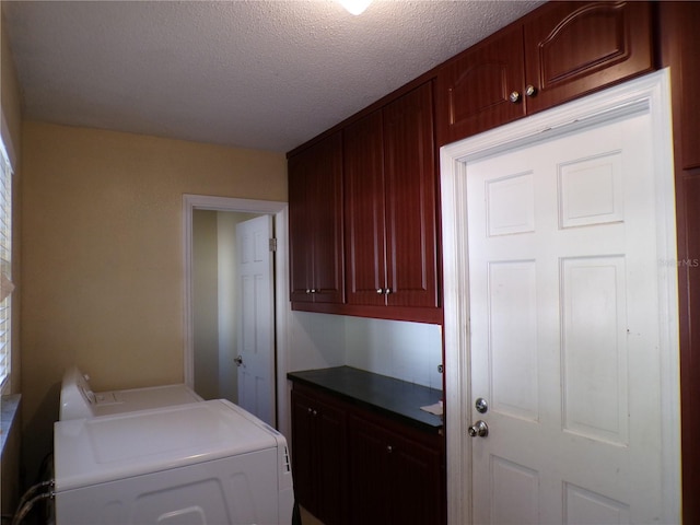 washroom with washer / clothes dryer, cabinet space, and a textured ceiling