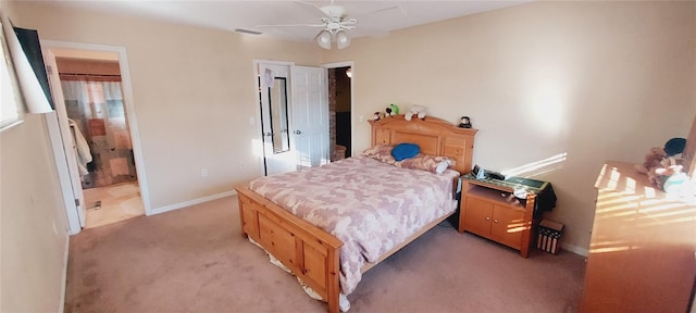 bedroom featuring light carpet, baseboards, visible vents, ceiling fan, and ensuite bathroom