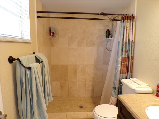 bathroom featuring a tile shower, vanity, and toilet